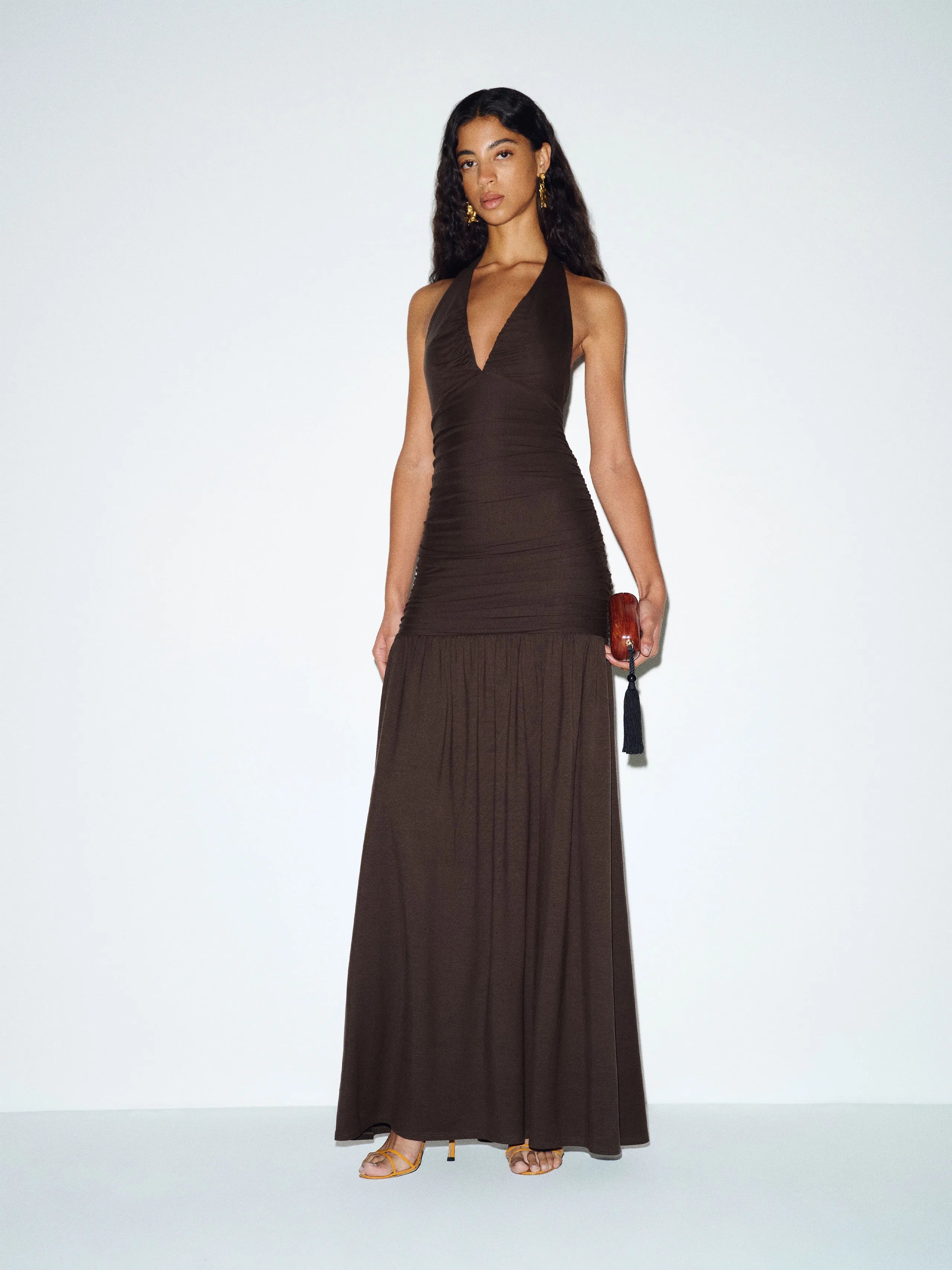 Woman wearing brown halter neck knit maxi dress with flowing skirt — Reformation | Endless UAE