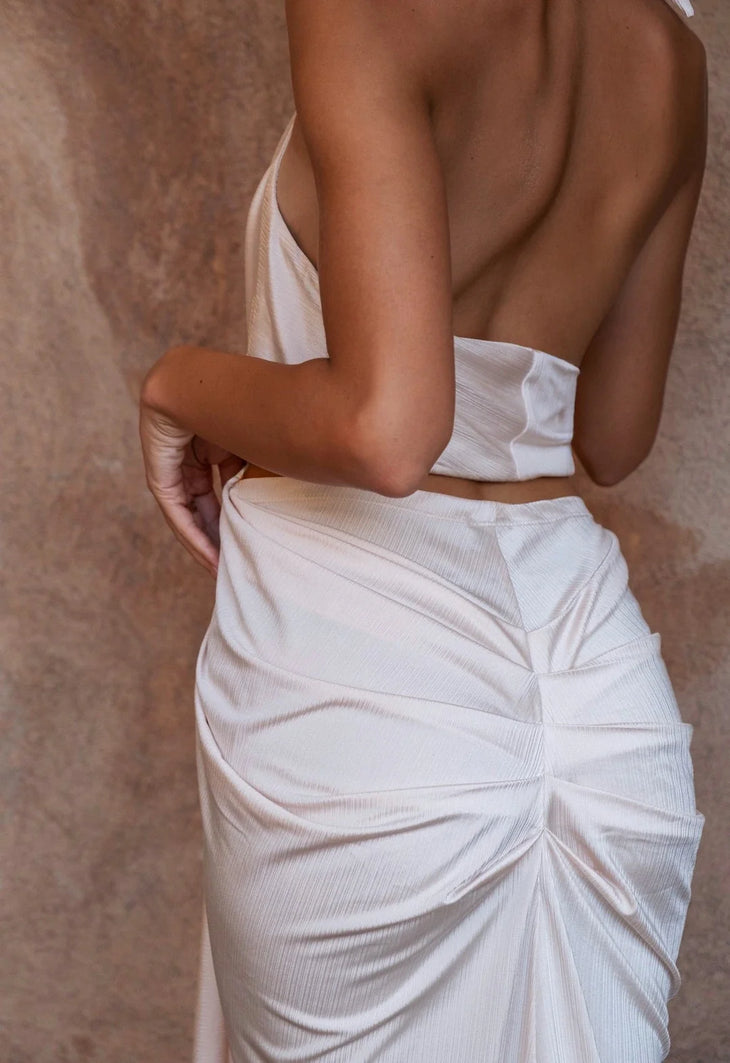 The Amalfi Gown in cream features a plunging halter neckline and draped silhouette — Melissa Phair | Endless UAE