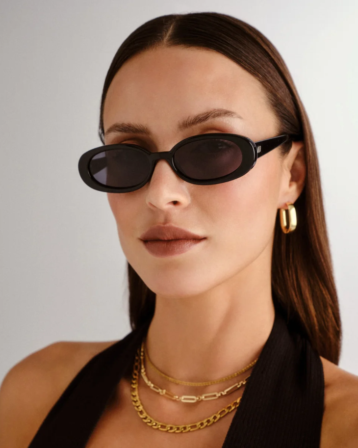 Black oval sunglasses with smoke-tinted lenses and thick frames — Le specs | Endless UAE