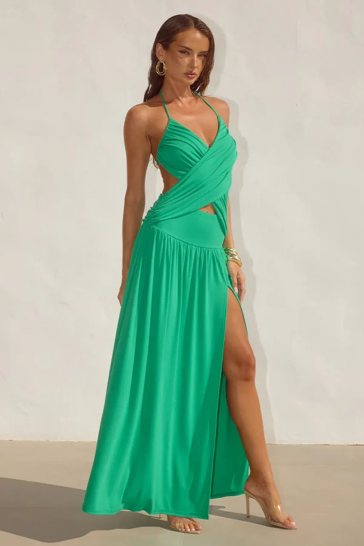 Woman wearing green halter maxi dress with cross-front cutout detail and pleated skirt — Runaway the Label | Endless UAE