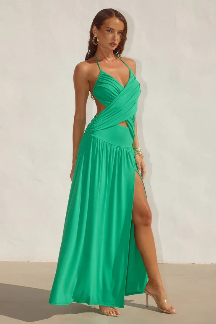 Woman wearing green halter maxi dress with cross-front cutout detail and pleated skirt — Runaway the Label | Endless UAE