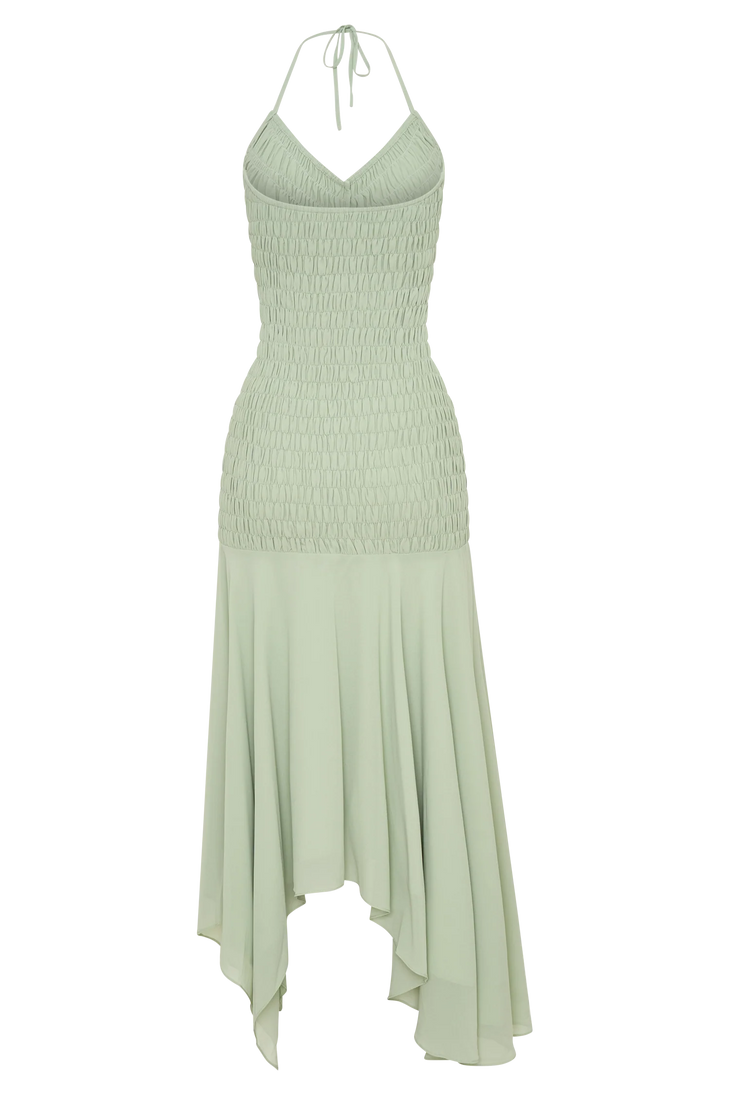 Woman wearing pale green halterneck maxi dress with shirred bodice and asymmetrical hem — Meshki | Endless UAE