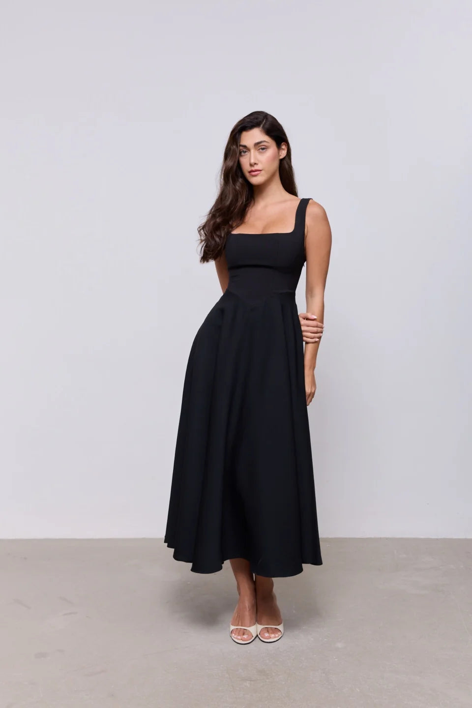 Woman wearing black square neck midi dress with white slides against neutral background — Odd Muse | Endless UAE