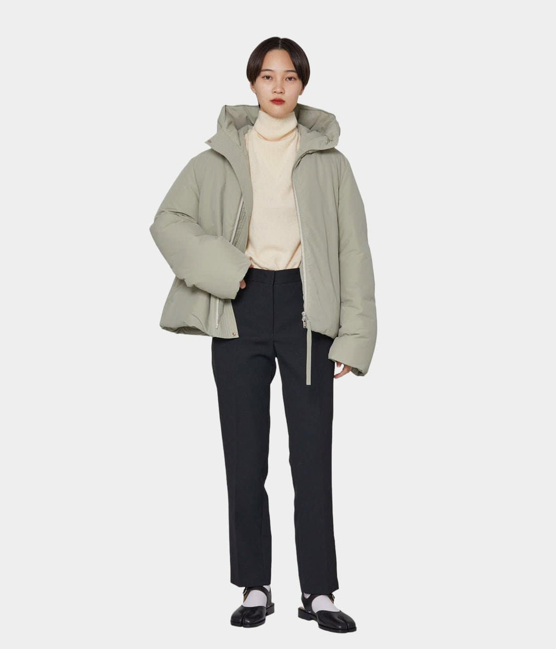 Beige puffer jacket with hood worn over dark trousers, back view — Jil Sander | Endless UAE