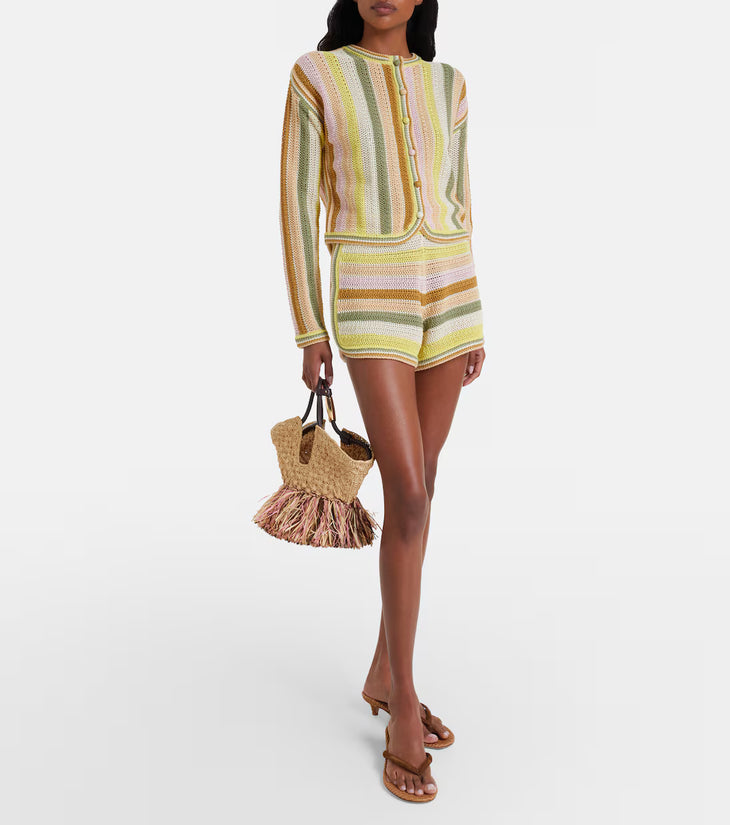 Woman wearing yellow striped crochet shorts set with matching cardigan and straw bag — Zimmermann | Endless UAE