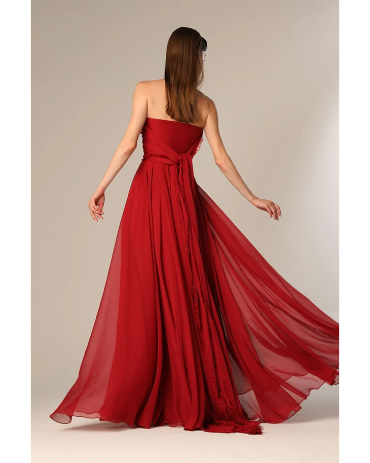 Woman wearing deep red strapless flowing gown with draped train — Velvety Couture | Endless UAE