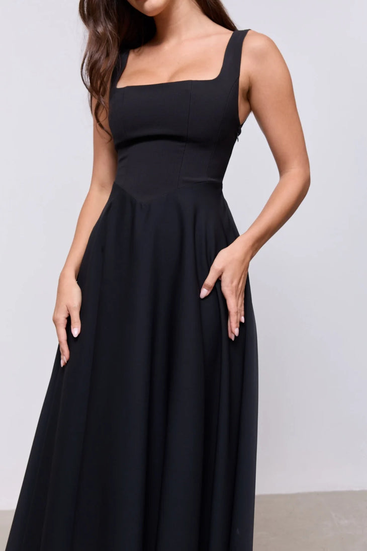 Woman wearing black square neck midi dress with white slides against neutral background — Odd Muse | Endless UAE