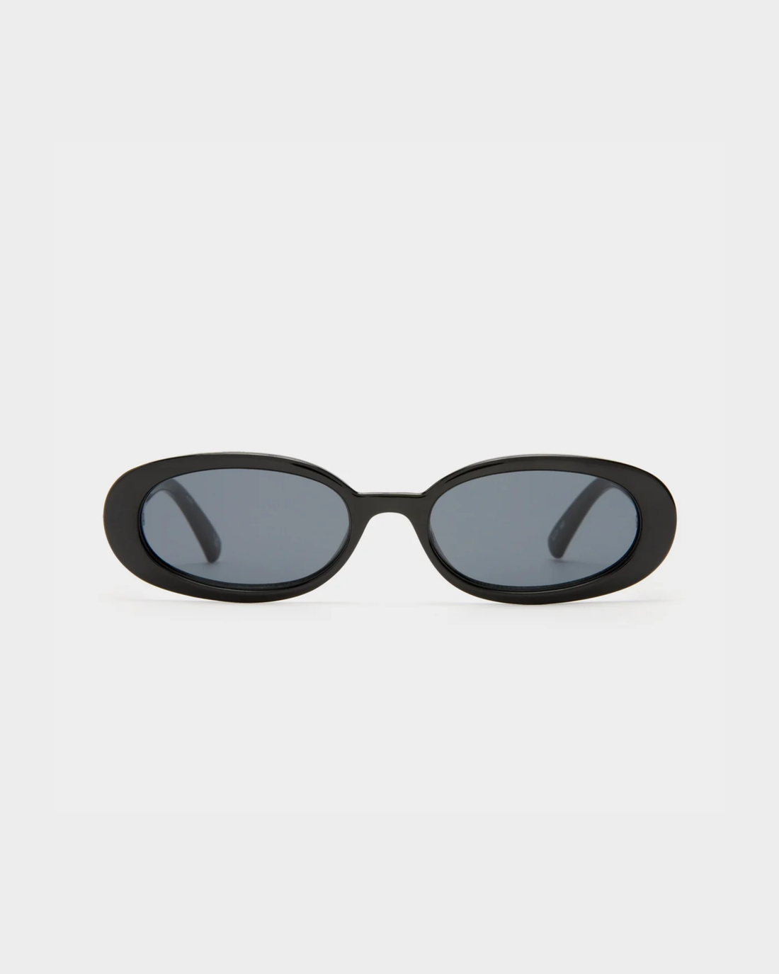 Black oval sunglasses with smoke-tinted lenses and thick frames — Le specs | Endless UAE