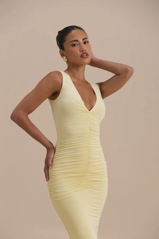 Woman wearing a pale yellow sleeveless maxi dress with ruched detailing — Wanderdoll | Endless UAE