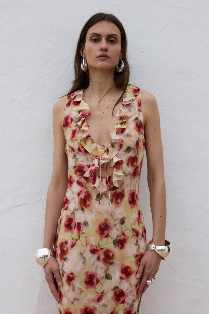 Woman wearing red floral midi dress against white wall — De La Vali | Endless UAE