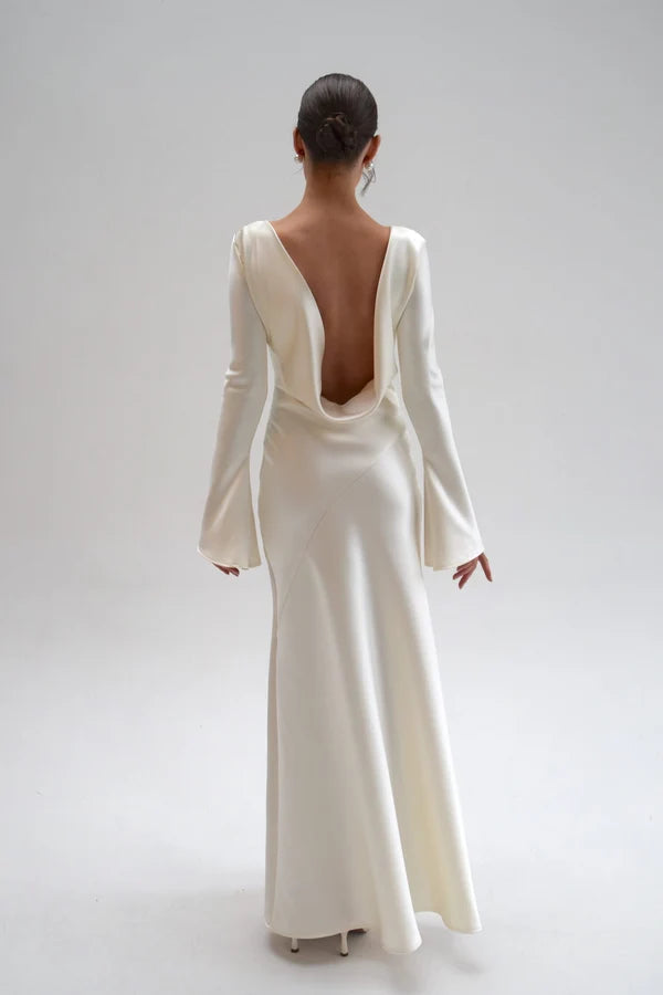 Bride in white satin Eden Dress holding white flowers — One Addington | Endless UAE