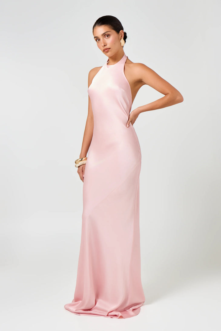Woman wearing pink Infinity Maxi Dress with halter neckline and gold hoop earrings — Hyphen | Endless UAE