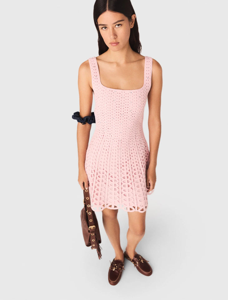 Woman wearing pink rhinestone crochet dress with navy ruffle sleeves and brown shoulder bag — Maje | Endless UAE
