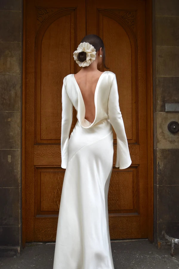 Bride in white satin Eden Dress holding white flowers — One Addington | Endless UAE