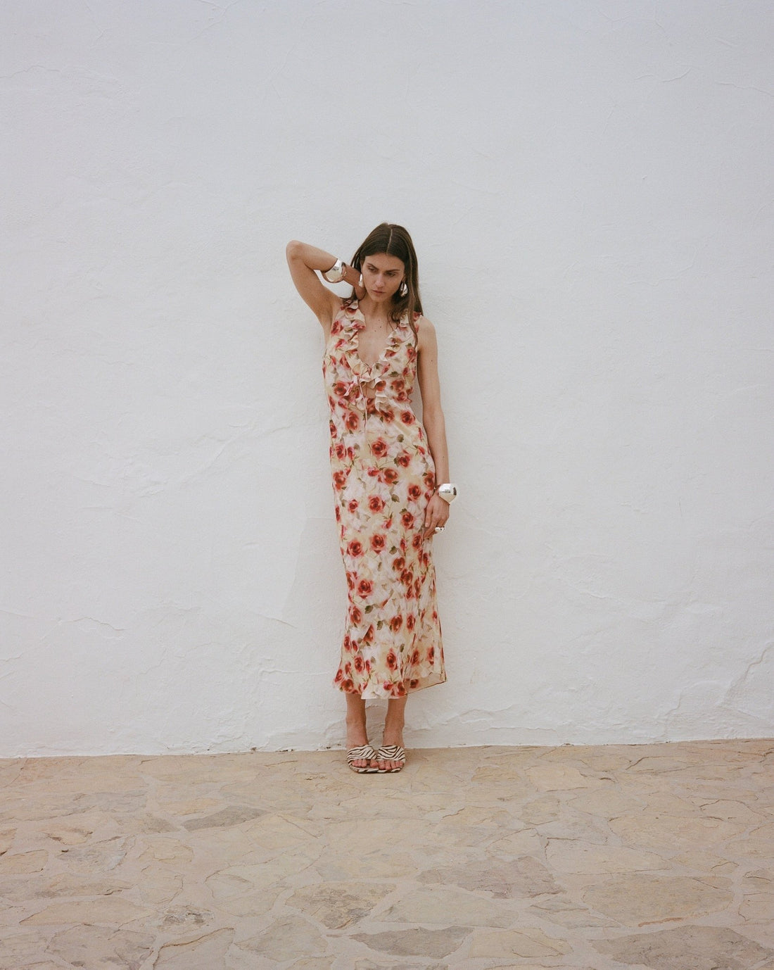 Woman wearing red floral midi dress against white wall — De La Vali | Endless UAE
