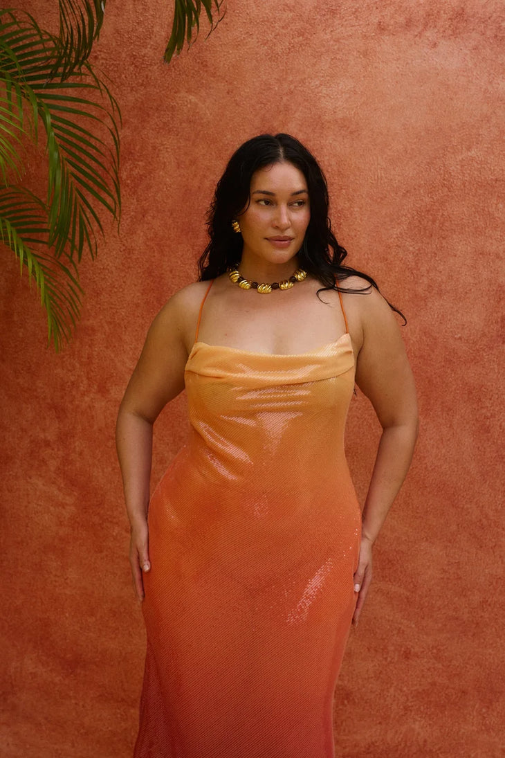 Woman wearing red ombre sequin strapless maxi dress against yellow wall — Bydee | Endless UAE
