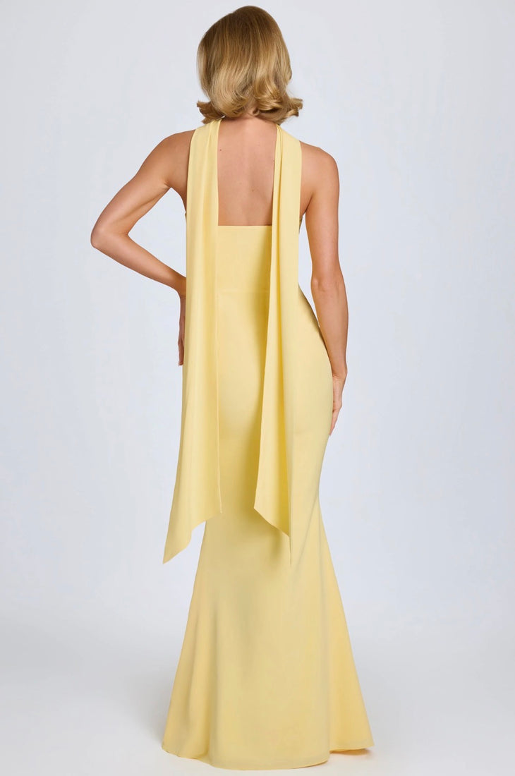 Woman wearing yellow strapless gown with draped scarf detail standing at entrance — Oh Polly | Endless UAE