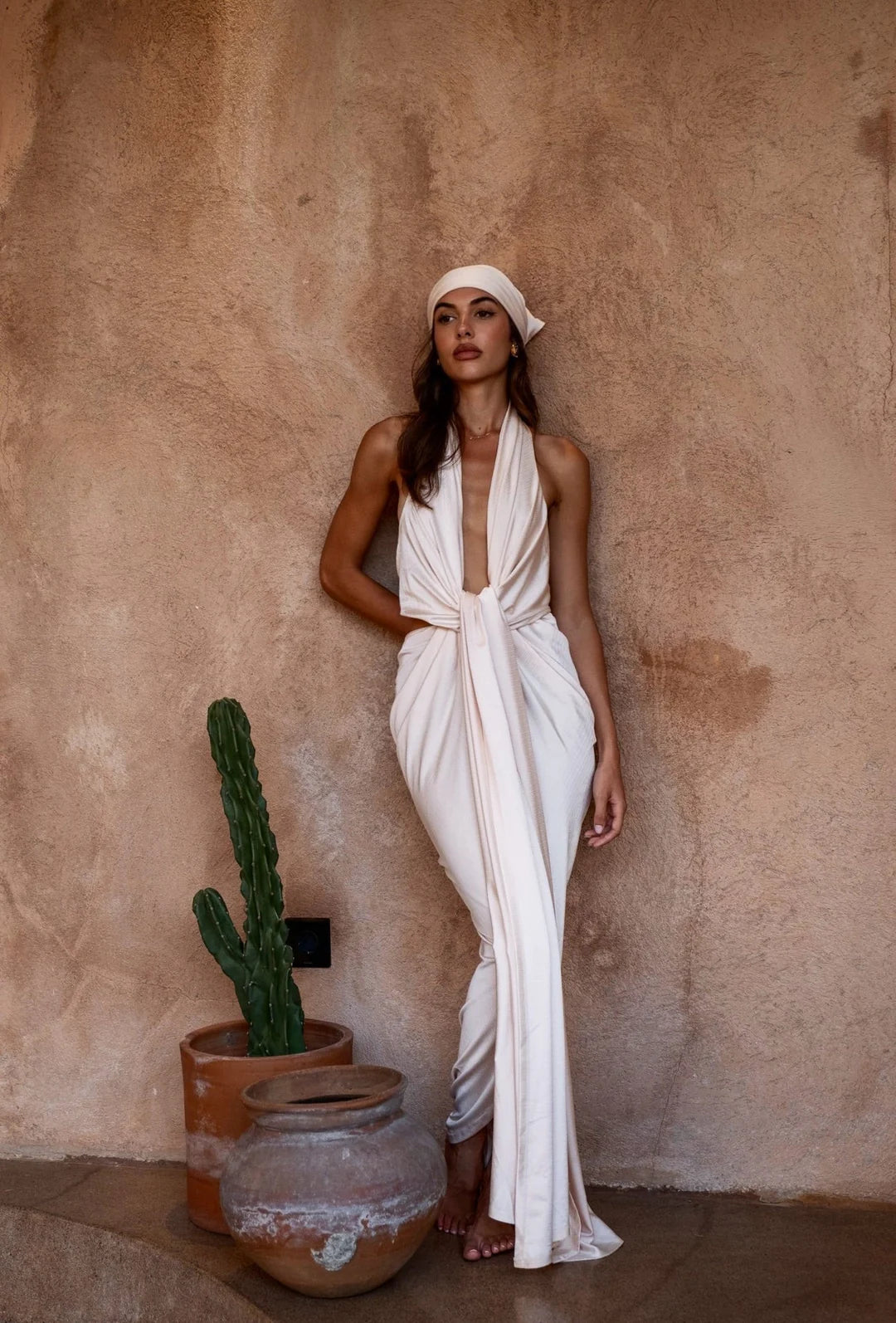The Amalfi Gown in cream features a plunging halter neckline and draped silhouette — Melissa Phair | Endless UAE
