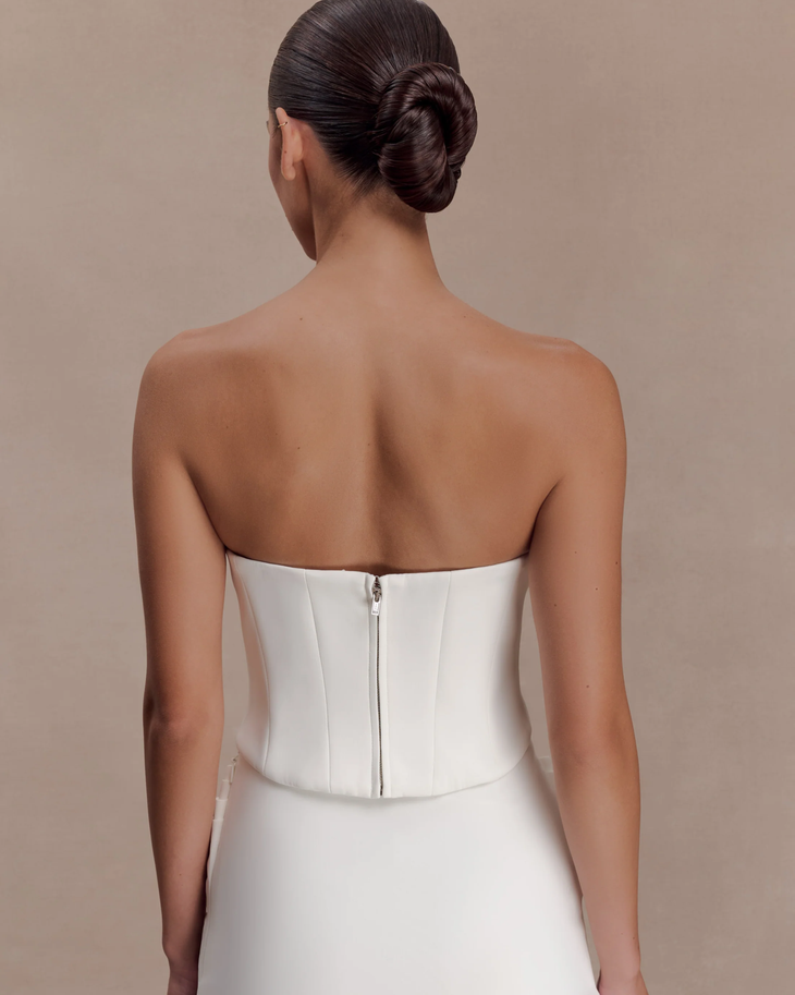 Woman wearing white strapless scuba corset with structured bodice and ruched detail — Meshki | Endless UAE