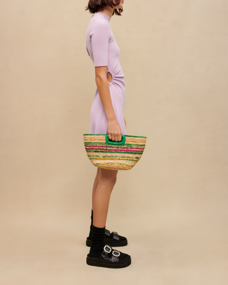 Woman wearing lavender ribbed midi dress with black socks and platform sandals holding colorful woven bag — Maje | Endless UAE