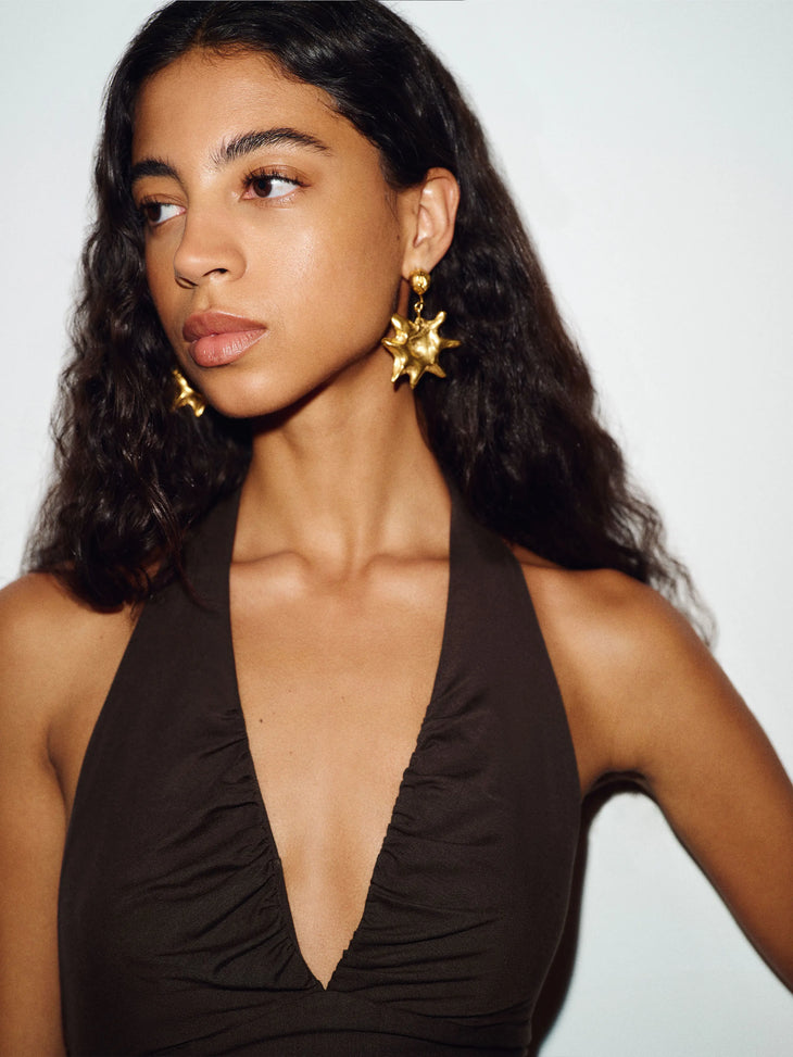 Woman wearing brown halter neck knit maxi dress with flowing skirt — Reformation | Endless UAE