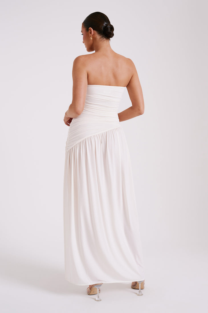 Woman wearing a white strapless ruched maxi dress with asymmetrical hem — Meshki | Endless UAE