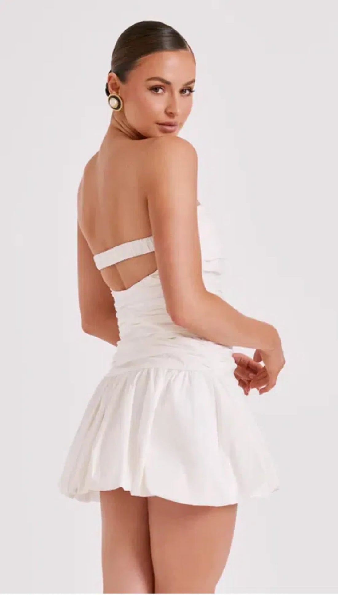 Woman wearing white strapless ruched cotton mini dress with circular earrings — Meshki | Endless UAE