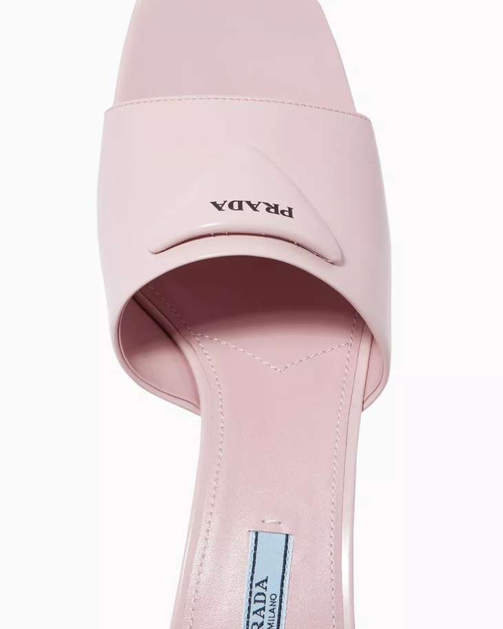 Light pink mule heels with triangle logo detail worn with black midi skirt — Prada | Endless UAE