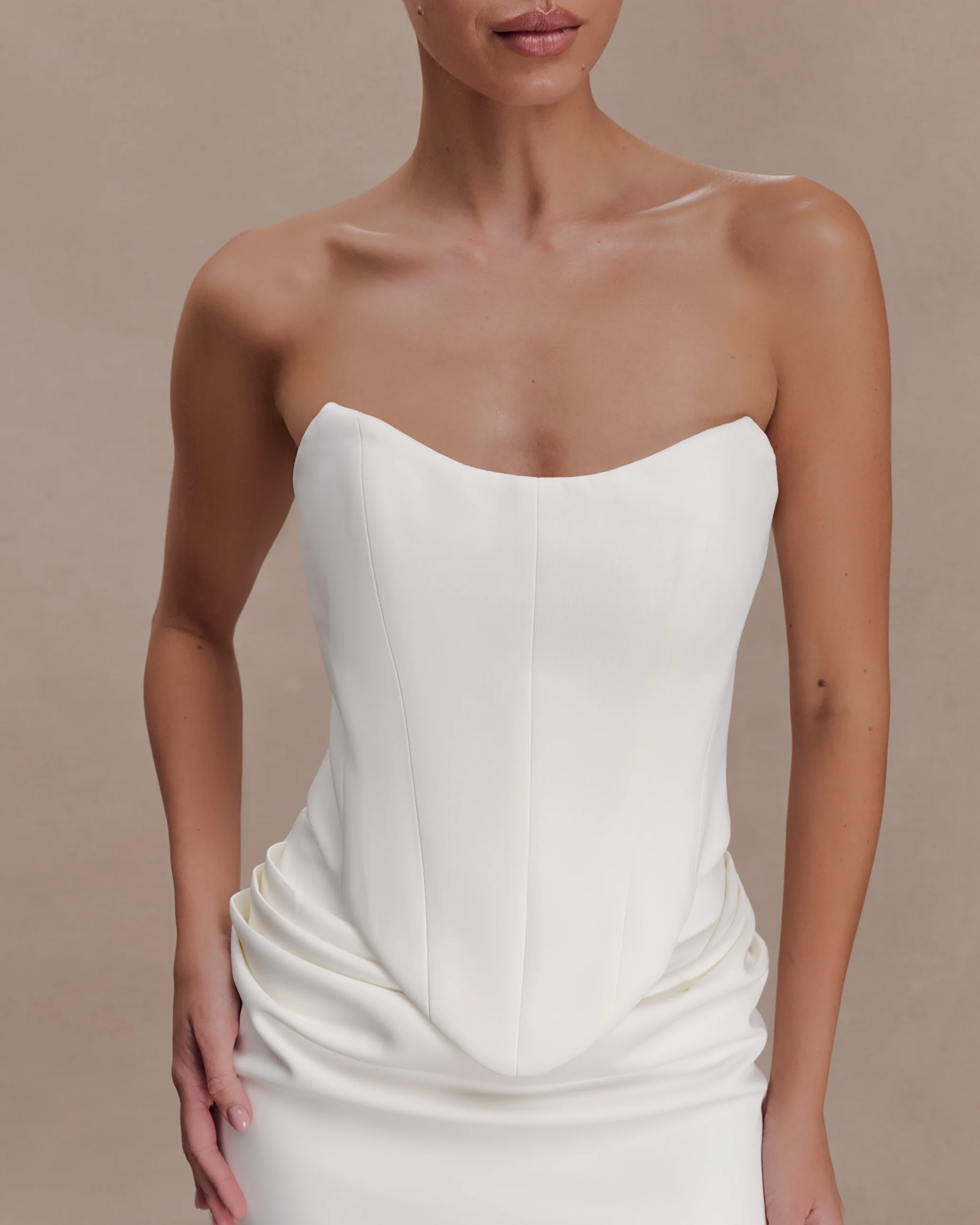 Woman wearing white strapless scuba corset with structured bodice and ruched detail — Meshki | Endless UAE