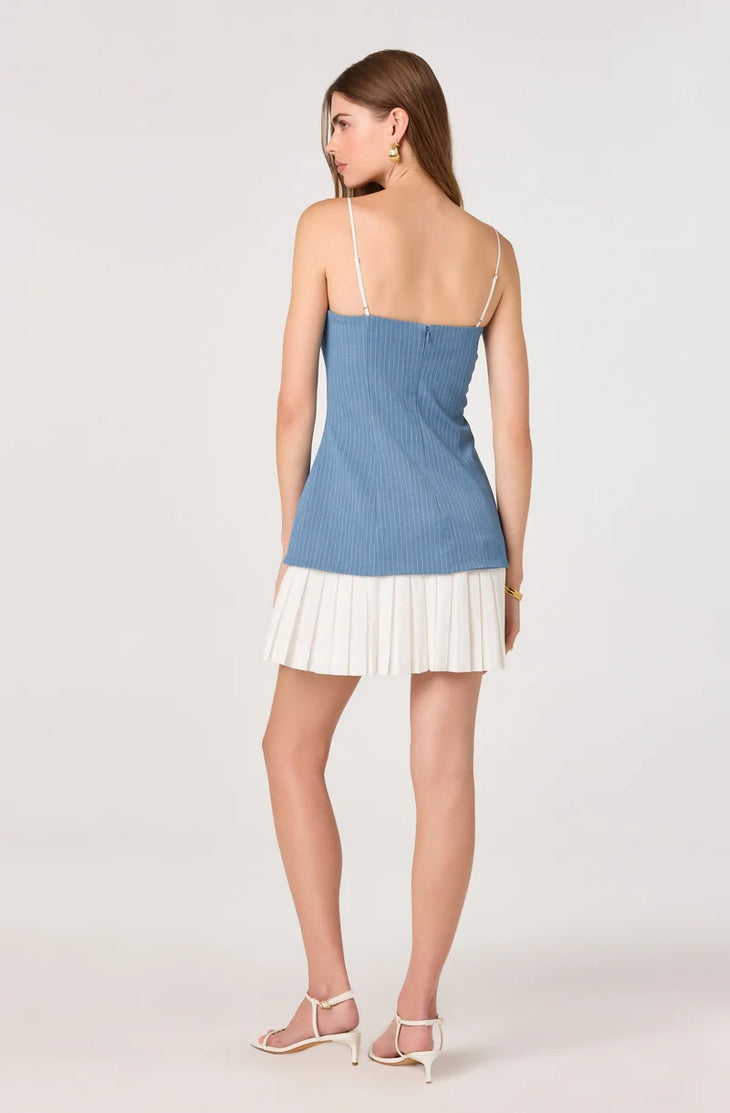 Woman wearing blue pinstriped denim camisole top with white pleated skirt bottom — ASTR the Label | Endless UAE