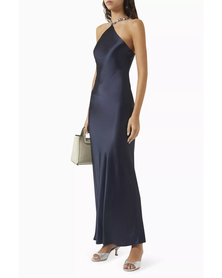 Woman wearing navy halter maxi dress with pearl-embellished neckline and metallic sandals — Staud | Endless UAE