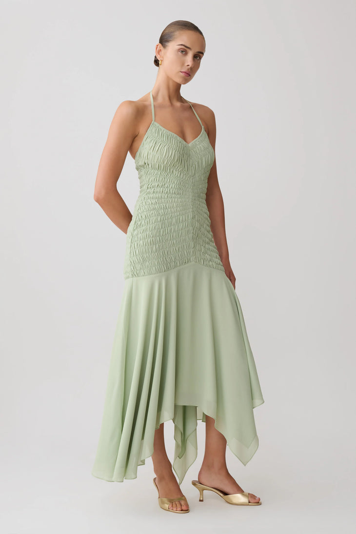 Woman wearing pale green halterneck maxi dress with shirred bodice and asymmetrical hem — Meshki | Endless UAE