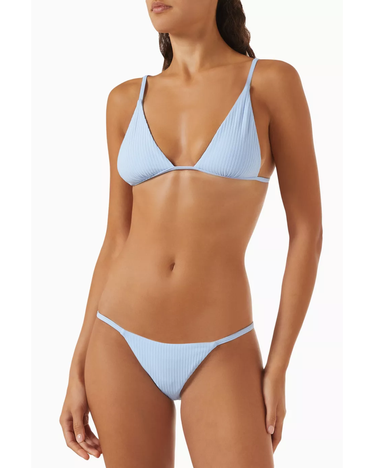 Woman wearing light blue ribbed triangle bikini top and matching bikini bottom — Monday Swimwear | Endless UAE