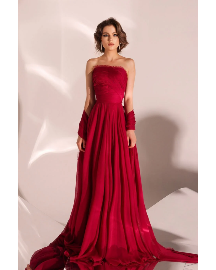 Woman wearing deep red strapless flowing gown with draped train — Velvety Couture | Endless UAE