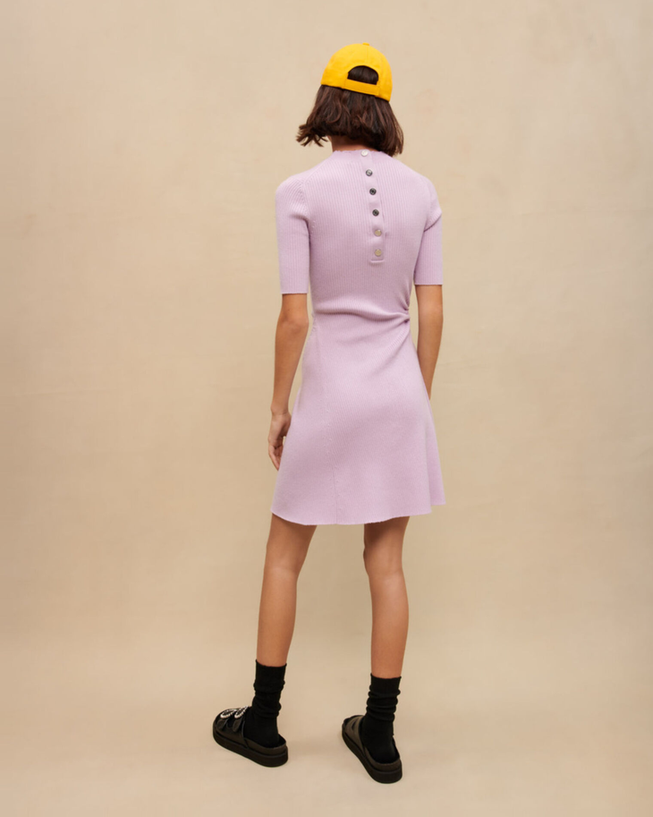 Woman wearing lavender ribbed midi dress with black socks and platform sandals holding colorful woven bag — Maje | Endless UAE