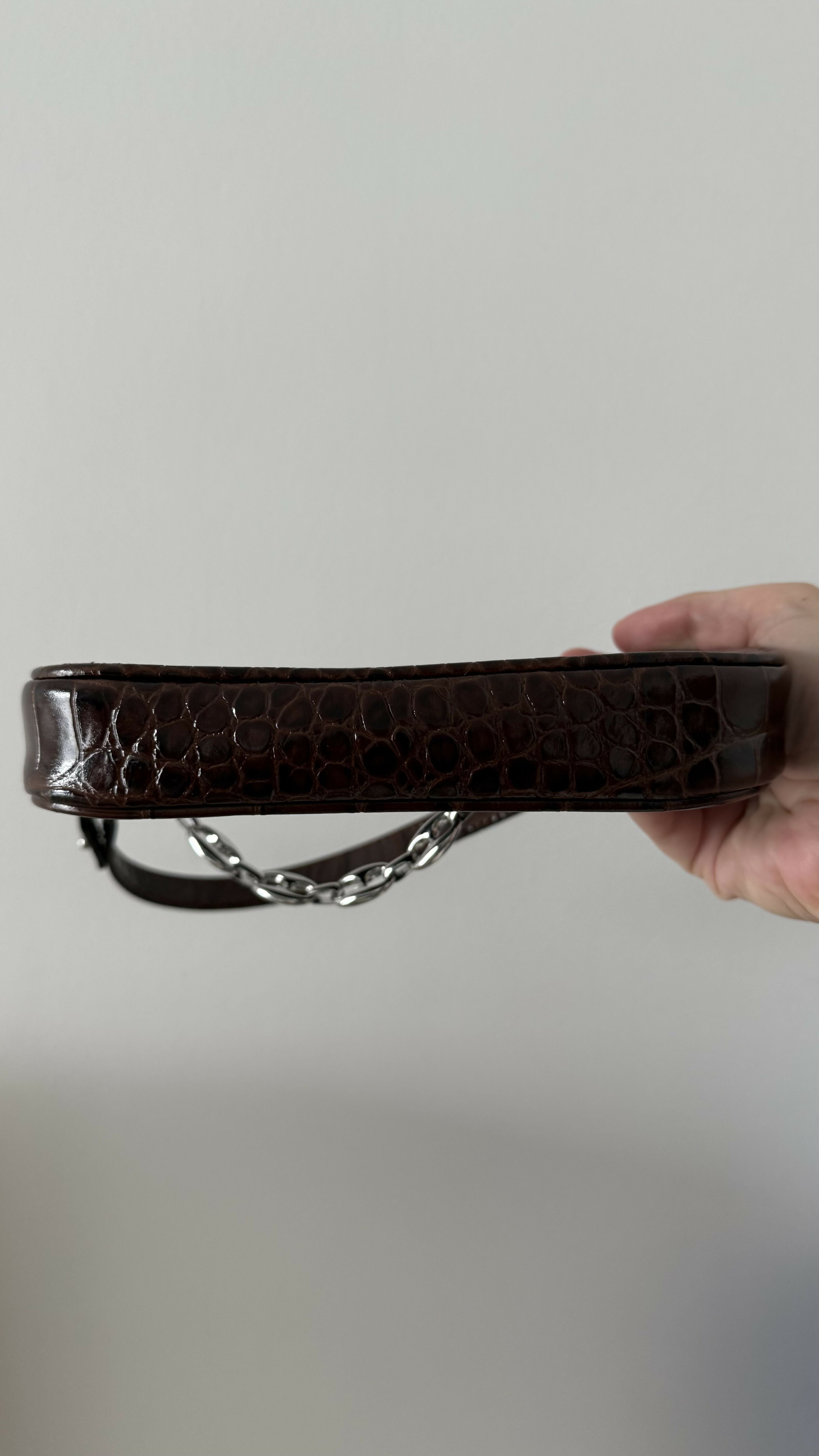 Dark brown croc-embossed mini shoulder bag with chain detail held in hand — By Far | Endless UAE