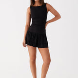Black sleeveless mini dress with ruched waist and tiered frill skirt — Peppermayo | Endless UAE
