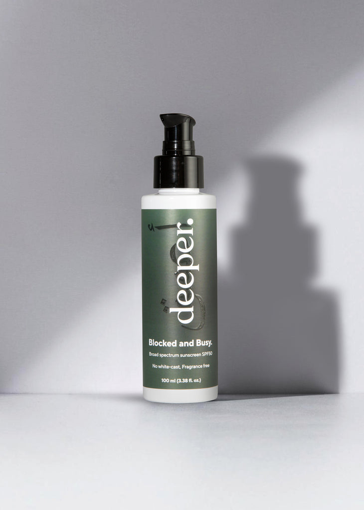 Deeper Beauty Blocked and Busy SPF 50 sunscreen bottle with pump dispenser on white surface — Deeper Beauty | Endless UAE