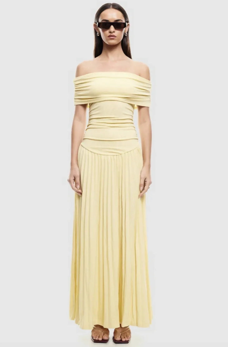 Woman wearing pale yellow off-shoulder maxi dress with ruched bodice and pleated skirt — Lioness | Endless UAE