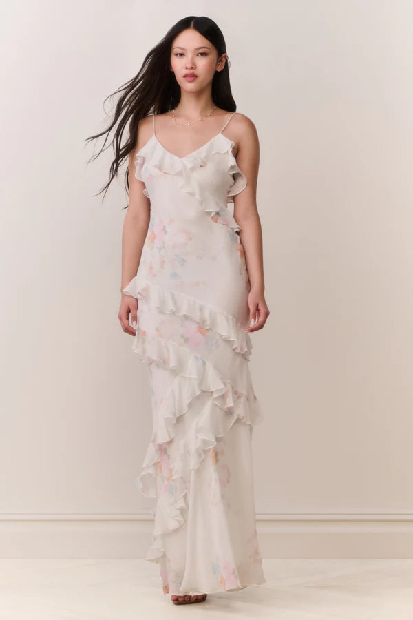 Woman modeling a cream floral ruffled maxi dress with delicate pastel details — LoveShackFancy | Endless UAE
