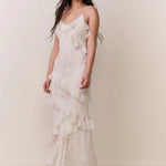 Woman modeling a cream floral ruffled maxi dress with delicate pastel details — LoveShackFancy | Endless UAE