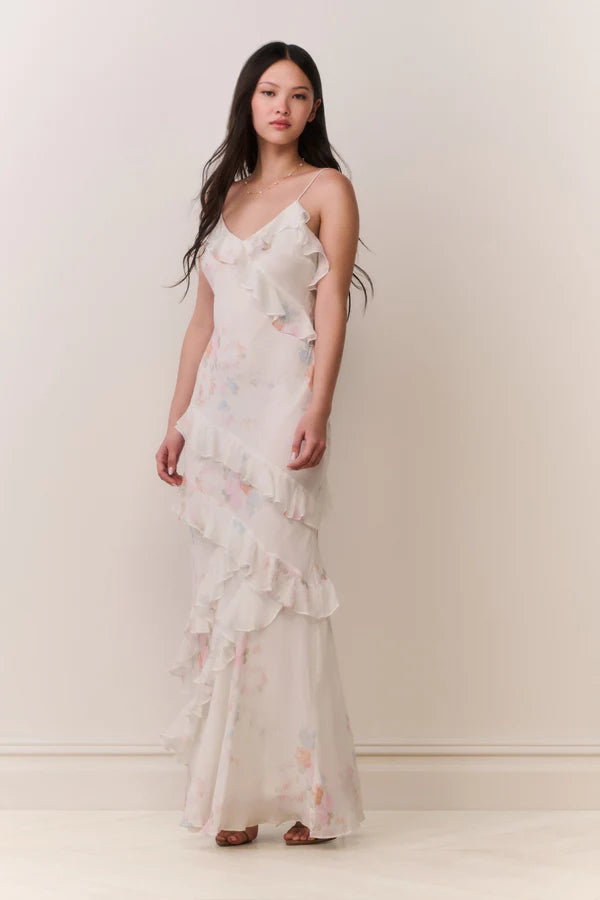 Woman modeling a cream floral ruffled maxi dress with delicate pastel details — LoveShackFancy | Endless UAE