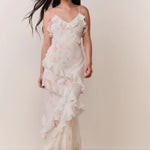 Woman modeling a cream floral ruffled maxi dress with delicate pastel details — LoveShackFancy | Endless UAE