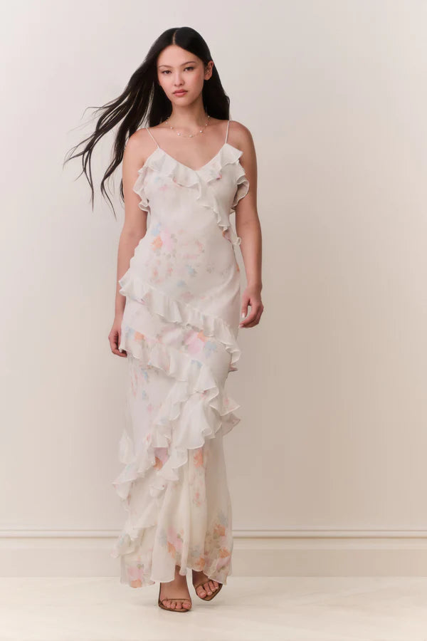 Woman modeling a cream floral ruffled maxi dress with delicate pastel details — LoveShackFancy | Endless UAE