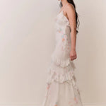 Woman modeling a cream floral ruffled maxi dress with delicate pastel details — LoveShackFancy | Endless UAE