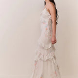 Woman modeling a cream floral ruffled maxi dress with delicate pastel details — LoveShackFancy | Endless UAE