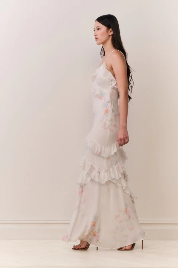 Woman modeling a cream floral ruffled maxi dress with delicate pastel details — LoveShackFancy | Endless UAE