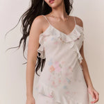 Woman modeling a cream floral ruffled maxi dress with delicate pastel details — LoveShackFancy | Endless UAE
