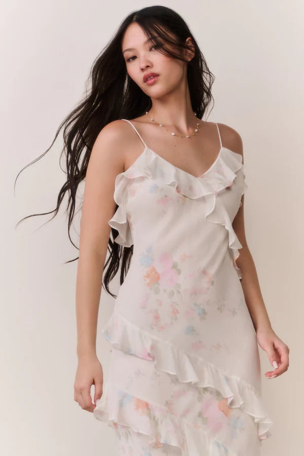 Woman modeling a cream floral ruffled maxi dress with delicate pastel details — LoveShackFancy | Endless UAE