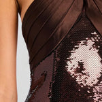 Woman wearing brown sequin halter dress with draped neckline and black heels — Retrofête | Endless UAE